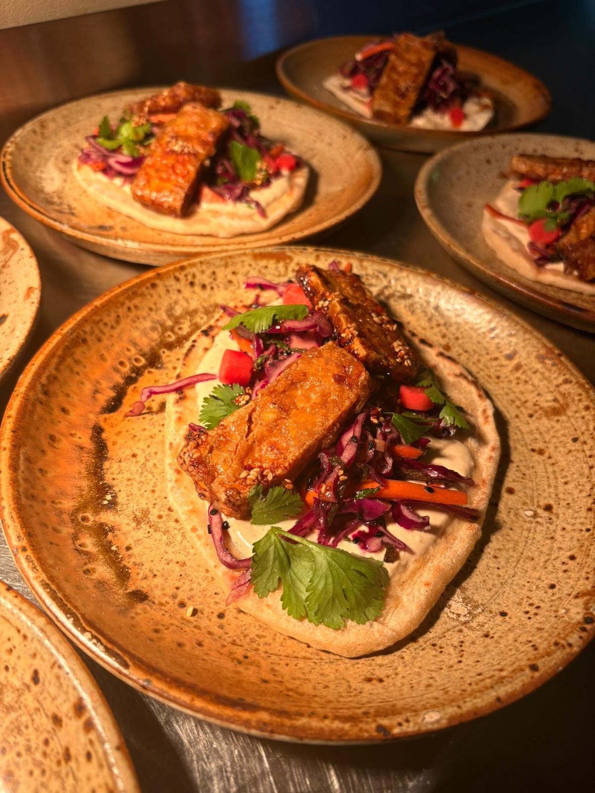 Tempeh grillé sur pain plat, houmous et chou rouge mariné